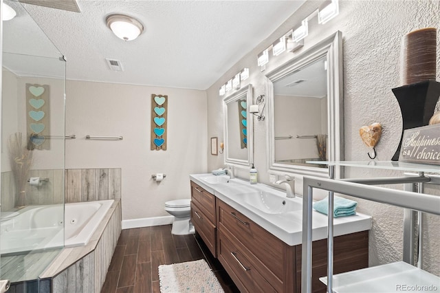 3625 Chase St, Wheat Ridge, CO 80212 - bathroom with tiled tub, baseboards, double vanity, toilet, and wood finished floors