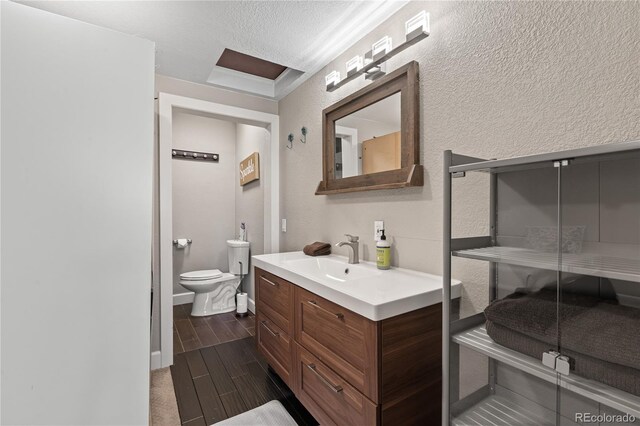 3625 Chase St, Wheat Ridge, CO 80212 - bathroom featuring vanity, wood finish floors, toilet, and a textured wall