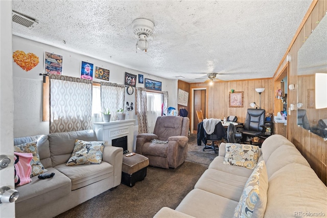 3625 Chase St, Wheat Ridge, CO 80212 - carpeted living room with ceiling fan, wooden walls, a textured ceiling, and a fireplace