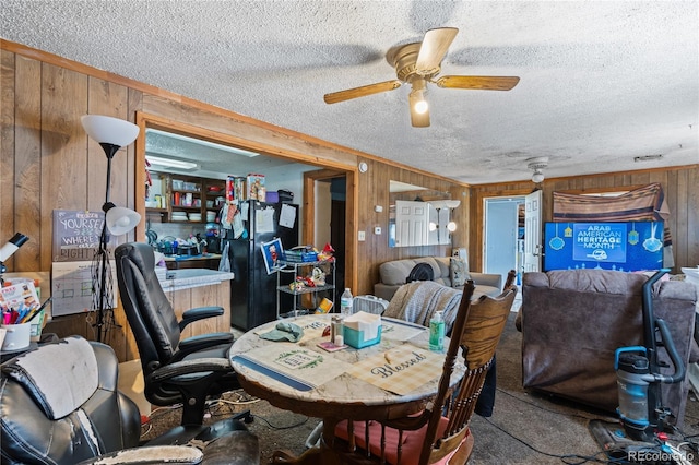 3625 Chase St, Wheat Ridge, CO 80212 - carpeted dining area featuring wooden walls, a textured ceiling, and a ceiling fan