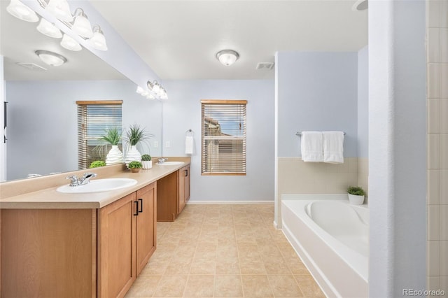 bathroom featuring double vanity, visible vents, a sink, and a garden tub