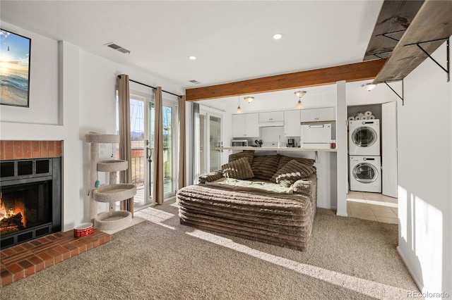 living room with light carpet, stacked washer / drying machine, a fireplace, beam ceiling, and recessed lighting