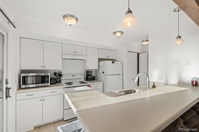 kitchen with a peninsula, white appliances, a breakfast bar, a sink, and white cabinetry