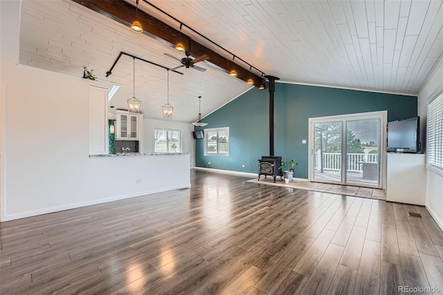 12189 Boot Hill Dr, Parker, CO 80138 - unfurnished living room with ceiling fan, a wood stove, wood finished floors, healthy amount of natural light, and wood ceiling