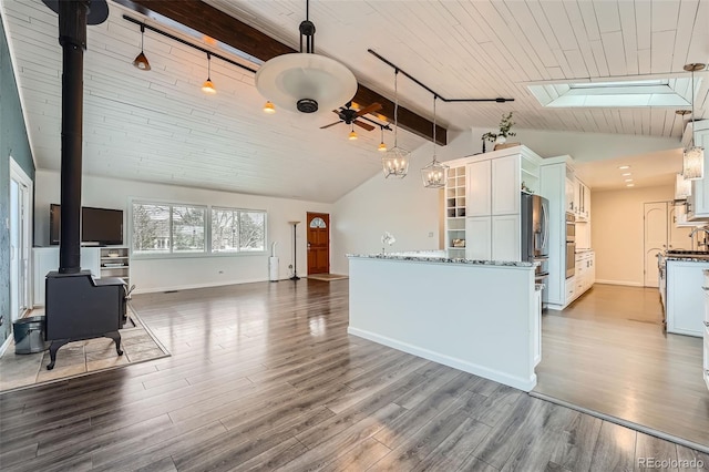 12189 Boot Hill Dr, Parker, CO 80138 - unfurnished living room featuring a wood stove, a skylight, wood finished floors, and wood ceiling