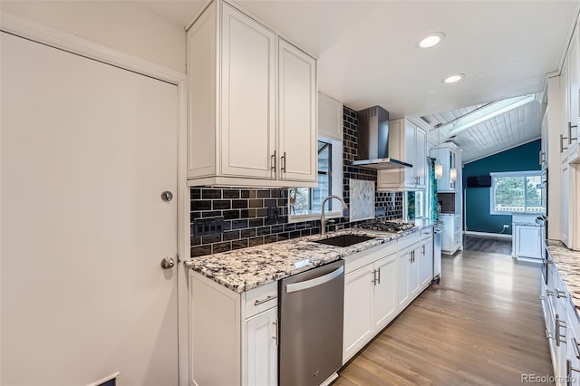 12189 Boot Hill Dr, Parker, CO 80138 - kitchen featuring appliances with stainless steel finishes, wall chimney exhaust hood, a sink, light wood-type flooring, and lofted ceiling