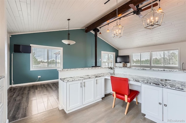 12189 Boot Hill Dr, Parker, CO 80138 - kitchen with white cabinets, a chandelier, wood finished floors, light stone countertops, and wood ceiling
