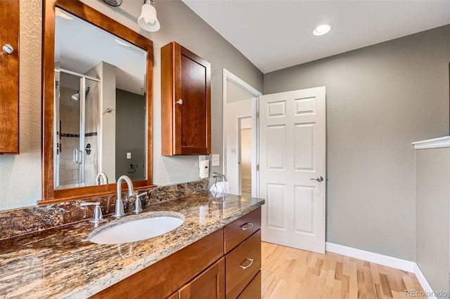 12189 Boot Hill Dr, Parker, CO 80138 - full bathroom featuring wood finished floors, vanity, a stall shower, and baseboards
