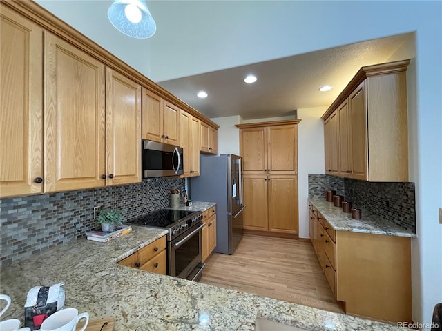 588 Stafford Cir, Castle Rock, CO 80104 - kitchen with appliances with stainless steel finishes, light stone counters, decorative backsplash, light wood finished floors, and recessed lighting