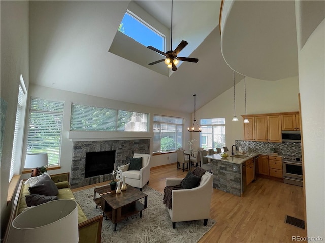 588 Stafford Cir, Castle Rock, CO 80104 - living area featuring high vaulted ceiling, a fireplace, light wood-type flooring, and a ceiling fan