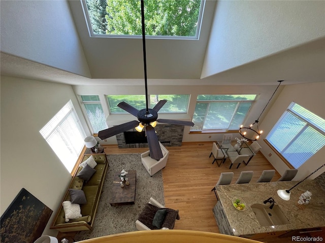 588 Stafford Cir, Castle Rock, CO 80104 - living area featuring a towering ceiling, wood finished floors, plenty of natural light, and a ceiling fan