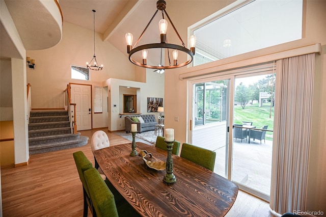 588 Stafford Cir, Castle Rock, CO 80104 - dining area with a chandelier, light wood-style flooring, stairway, and a towering ceiling