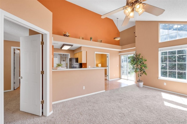 13782 E Lehigh Ave Unit H, Aurora, CO 80014 - unfurnished living room with light carpet, high vaulted ceiling, and ceiling fan