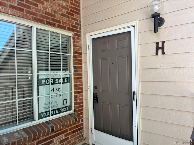 13782 E Lehigh Ave Unit H, Aurora, CO 80014 - property entrance featuring brick siding