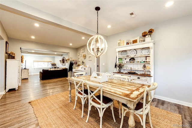 dining area featuring baseboards, wood finished floors, visible vents, and recessed lighting