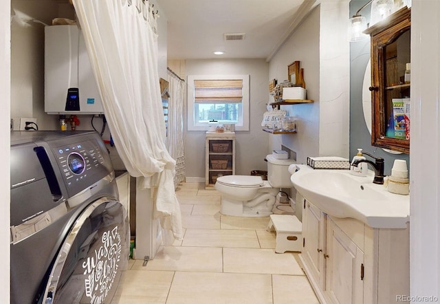 bathroom with washer / dryer, toilet, tile patterned floors, tankless water heater, and vanity