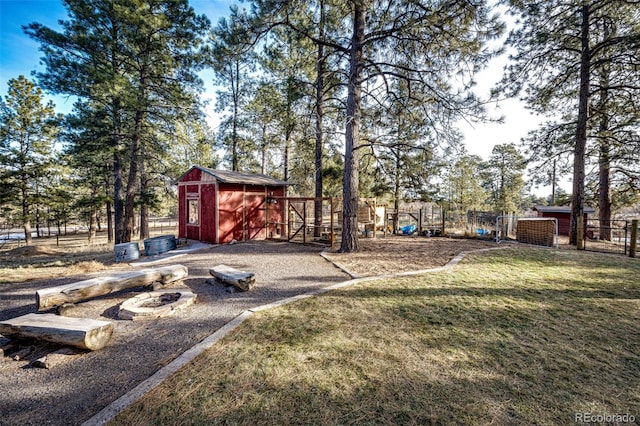 view of yard with an outbuilding, a storage unit, and fence