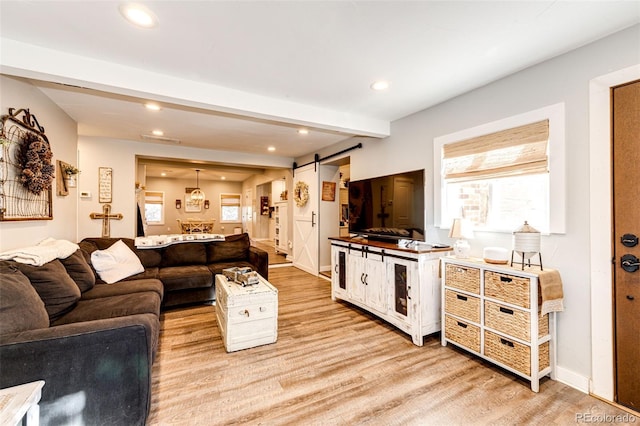 living room featuring light wood-style floors, a barn door, beam ceiling, and recessed lighting