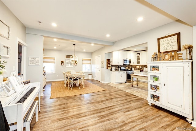 interior space featuring a chandelier, light wood-type flooring, baseboards, and recessed lighting