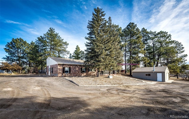 view of front of property with an outbuilding and brick siding