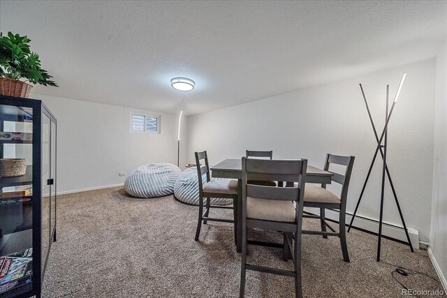 carpeted dining area with a textured ceiling and baseboard heating