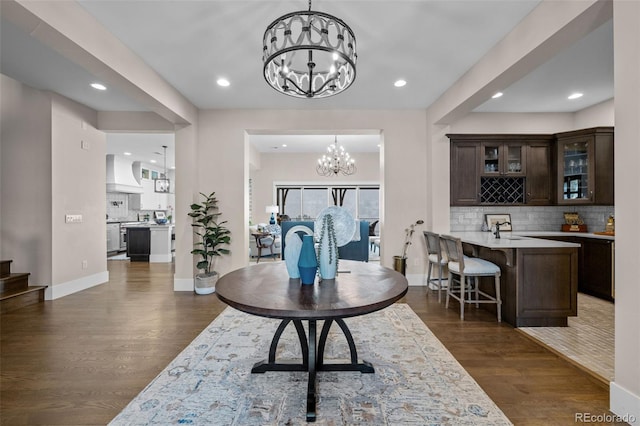 foyer featuring dark wood-type flooring, recessed lighting, baseboards, and a notable chandelier