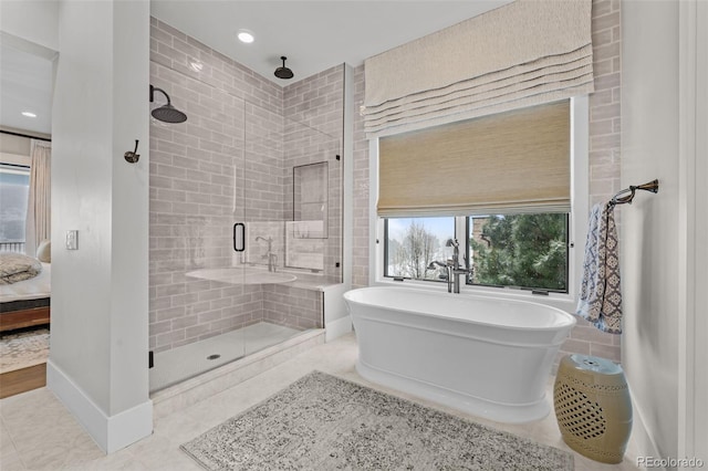 bathroom featuring a freestanding tub, tile patterned flooring, and a stall shower