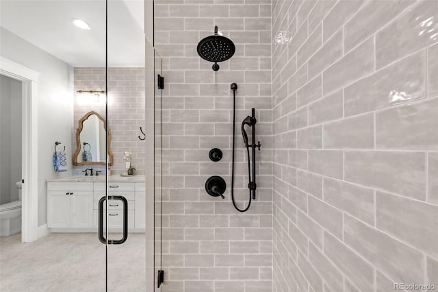 bathroom featuring vanity, toilet, and a stall shower