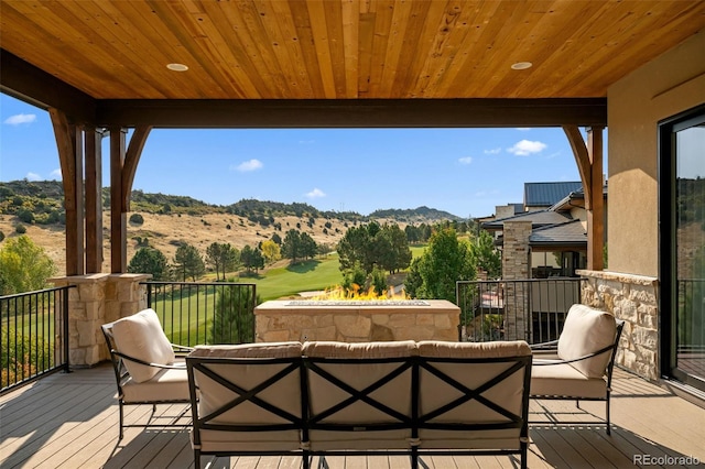 balcony featuring a mountain view and an outdoor living space with a fire pit