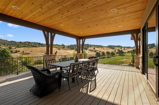 deck featuring outdoor dining area and a mountain view