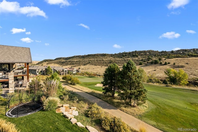 view of yard featuring a mountain view and view of golf course