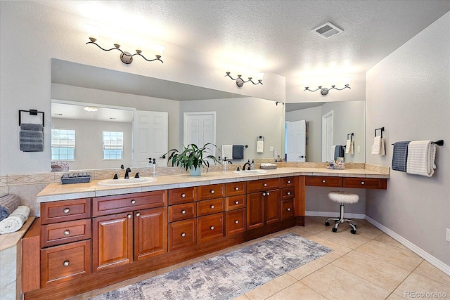 bathroom featuring a textured ceiling, tile patterned floors, and vanity