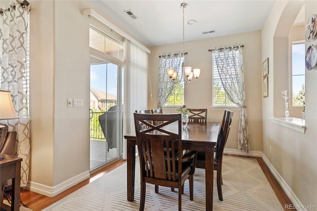 10064 Bluffmont Ct, Lone Tree, CO 80124 - dining area featuring wood finished floors, a chandelier, and arched walkways