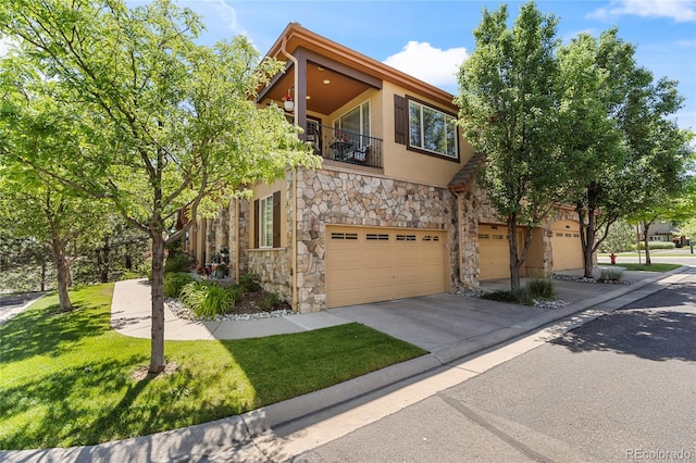 10064 Bluffmont Ct, Lone Tree, CO 80124 - view of front of house featuring stone siding, a balcony, an attached garage, driveway, and stucco siding