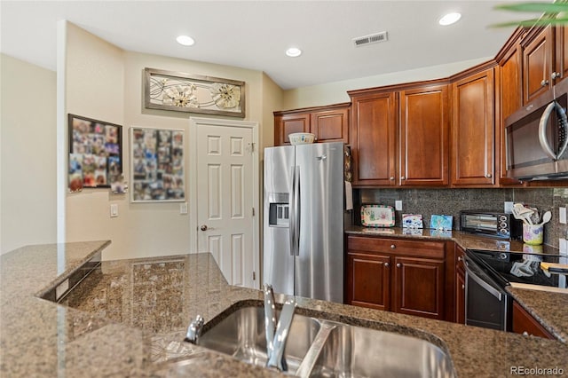 10064 Bluffmont Ct, Lone Tree, CO 80124 - kitchen with stainless steel appliances, dark stone counters, tasteful backsplash, and recessed lighting