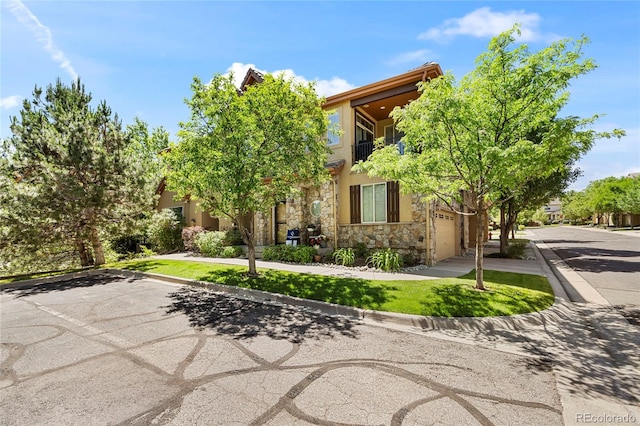 10064 Bluffmont Ct, Lone Tree, CO 80124 - view of property hidden behind natural elements with a garage, stone siding, driveway, and stucco siding