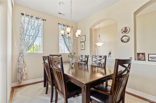 10064 Bluffmont Ct, Lone Tree, CO 80124 - dining room with arched walkways, a chandelier, and light wood-type flooring
