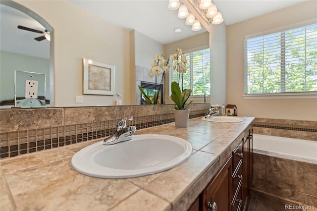 10064 Bluffmont Ct, Lone Tree, CO 80124 - full bath with double vanity, tiled bath, and a ceiling fan