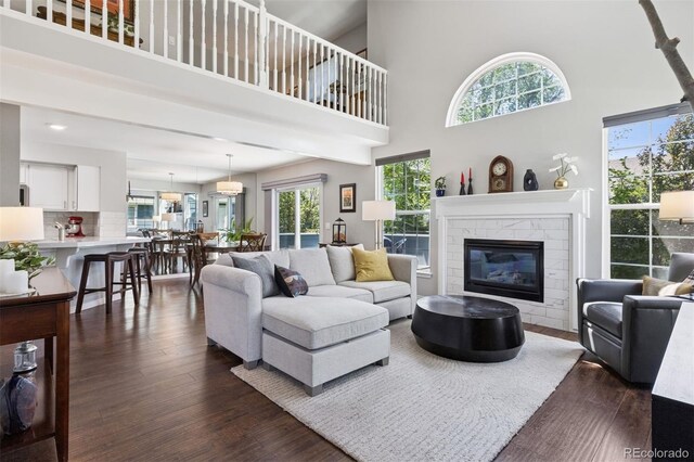 4976 S Nelson St Unit A, Littleton, CO 80127 - living area with a tile fireplace, dark wood-style floors, a high ceiling, and recessed lighting