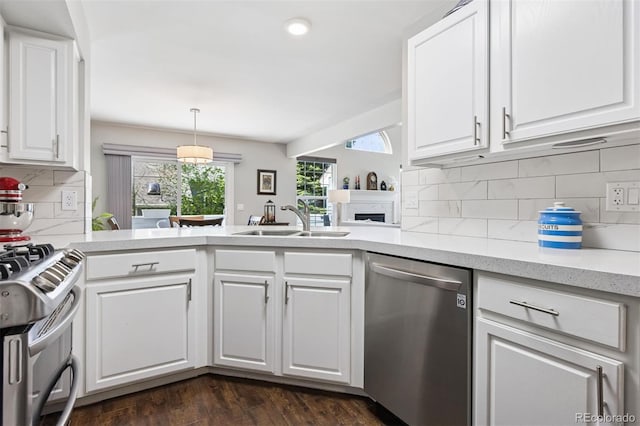 4976 S Nelson St Unit A, Littleton, CO 80127 - kitchen featuring stainless steel appliances, a sink, a peninsula, white cabinets, and backsplash