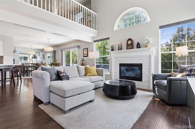 4976 S Nelson St Unit A, Littleton, CO 80127 - living area with dark wood-type flooring, healthy amount of natural light, a glass covered fireplace, and a towering ceiling
