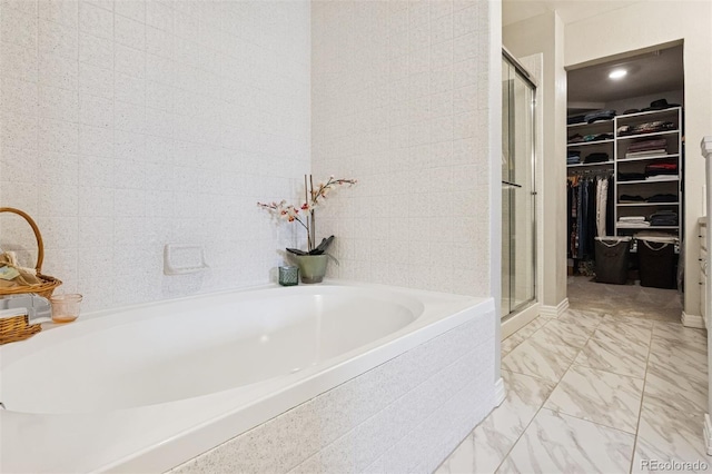 4976 S Nelson St Unit A, Littleton, CO 80127 - bathroom featuring a walk in closet, a shower stall, a garden tub, and marble look tiles