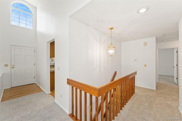 entryway featuring baseboards, a textured ceiling, and light colored carpet