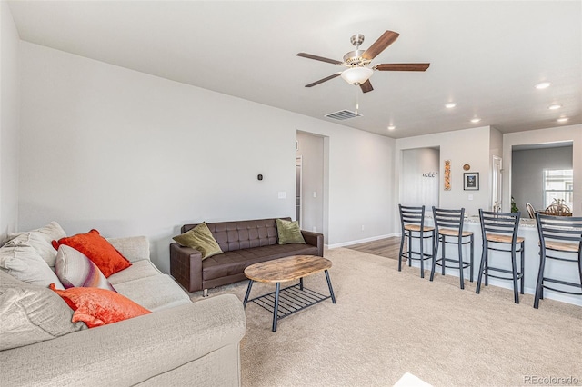 living room with light colored carpet and ceiling fan