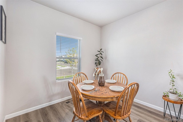 dining space with hardwood / wood-style flooring