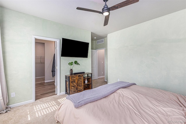 bedroom with ceiling fan, a spacious closet, carpet, and a closet