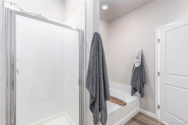 bathroom featuring wood-type flooring and independent shower and bath