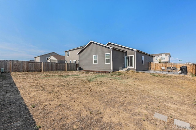 rear view of property featuring a patio area and a lawn