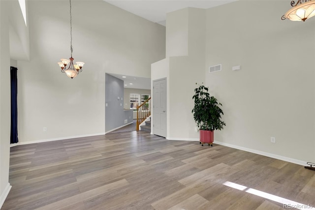 3109 S Jebel Way, Aurora, CO 80013 - unfurnished living room featuring a chandelier, stairway, wood finished floors, baseboards, and a high ceiling
