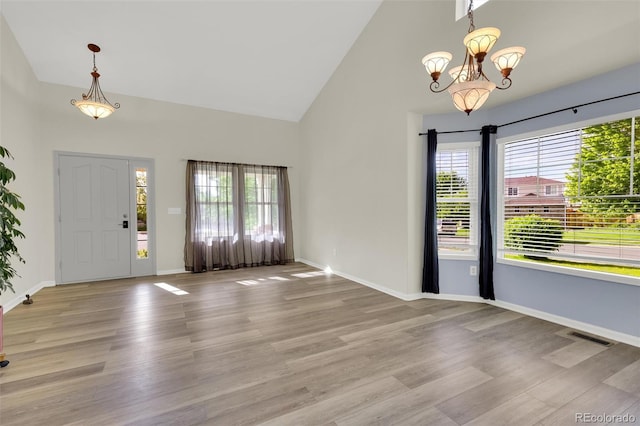 3109 S Jebel Way, Aurora, CO 80013 - entrance foyer with healthy amount of natural light, high vaulted ceiling, a chandelier, and light wood-style flooring